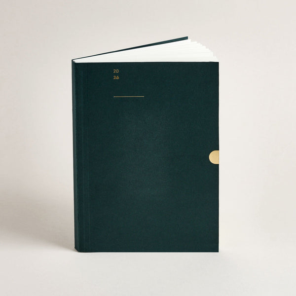 Mark+Fold 2026 Diary in dark green with gold accents on a light beige background