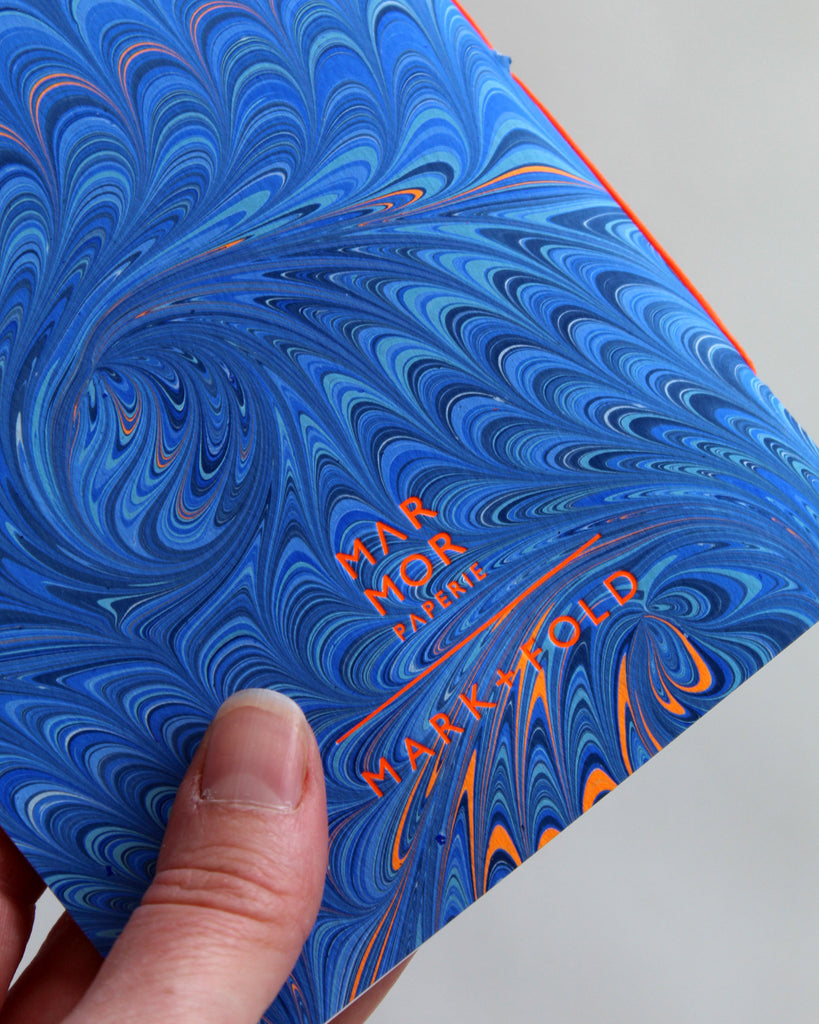 Detail of the Marmor for Mark+Fold logo in neon orange foil, printed in suffolk.