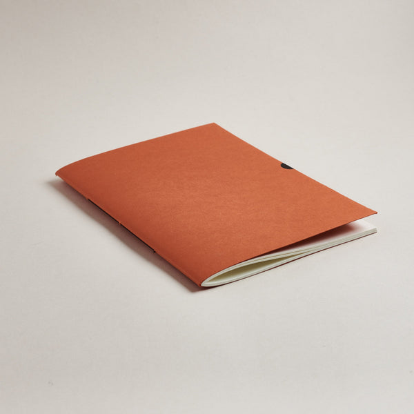 rust Orange a5 medium notebook on a light gray background