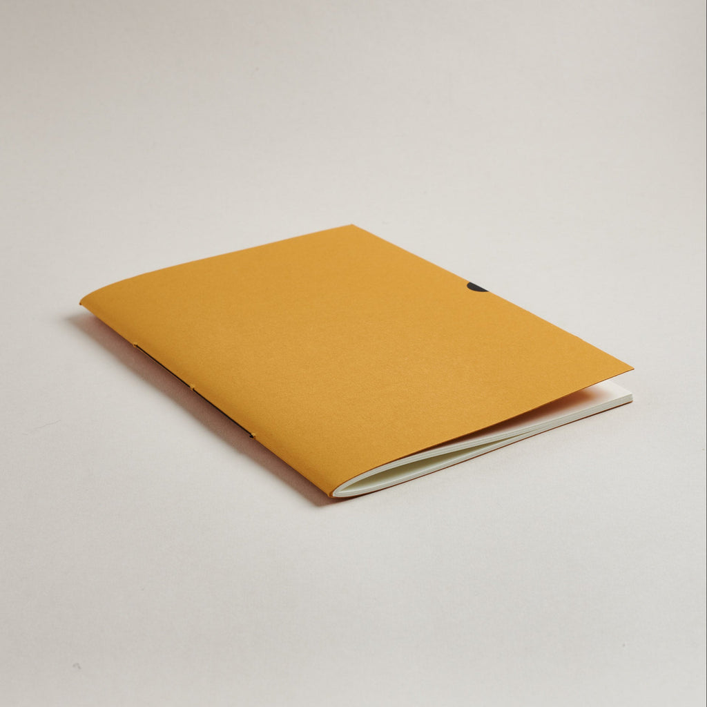 mustard Yellow a5 medium notebook on a light gray background