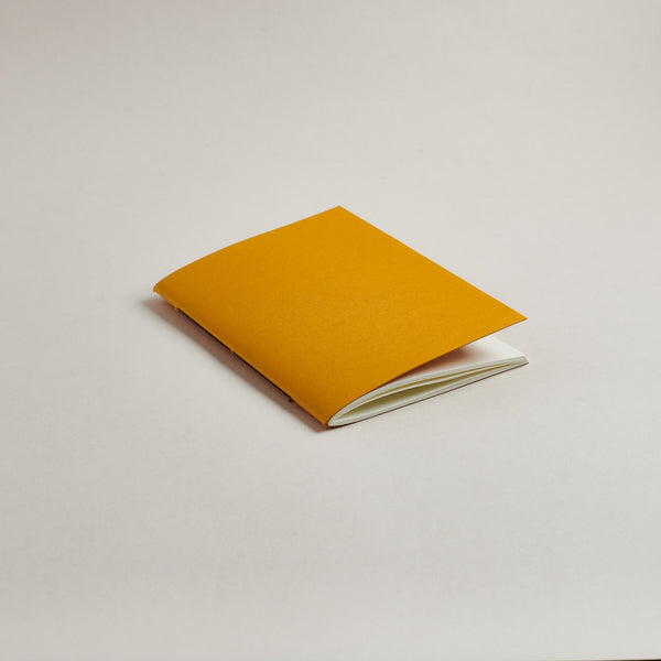 Mustard Yellow a6 pocket notebook on a light gray background