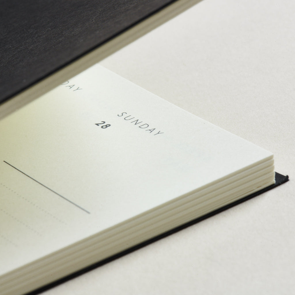Close-up of a mark+fold 2026 diary showing warm white pages and sunday typography