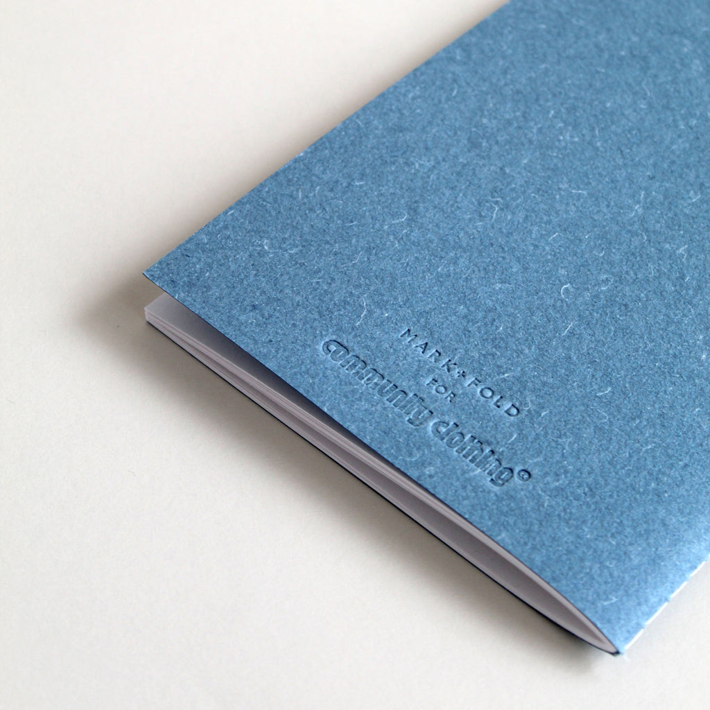 Blue notebook with Mark+Fold for Community Clothing logo