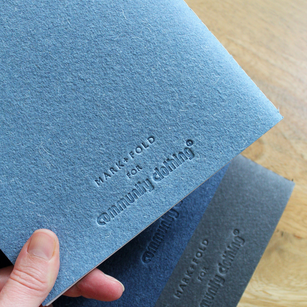 Blue, Indigo and Black notebooks with Mark+Fold for Community Clothing logo