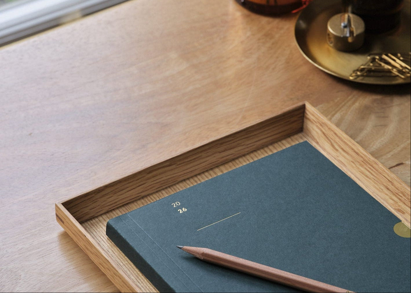 racing Green 2026 diary planner with a wooden pencil on a wooden desk