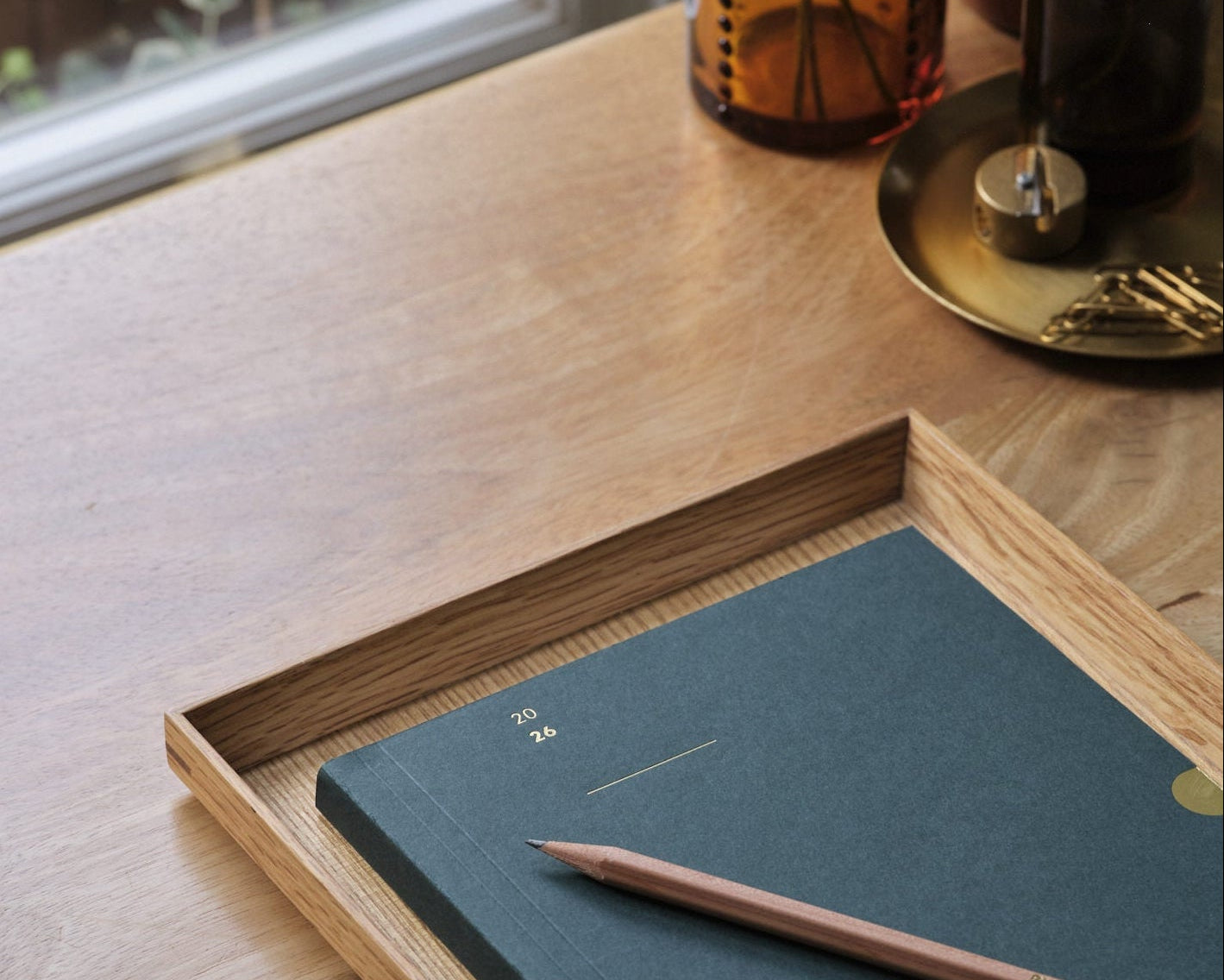racing Green 2026 diary planner with a wooden pencil on a wooden desk
