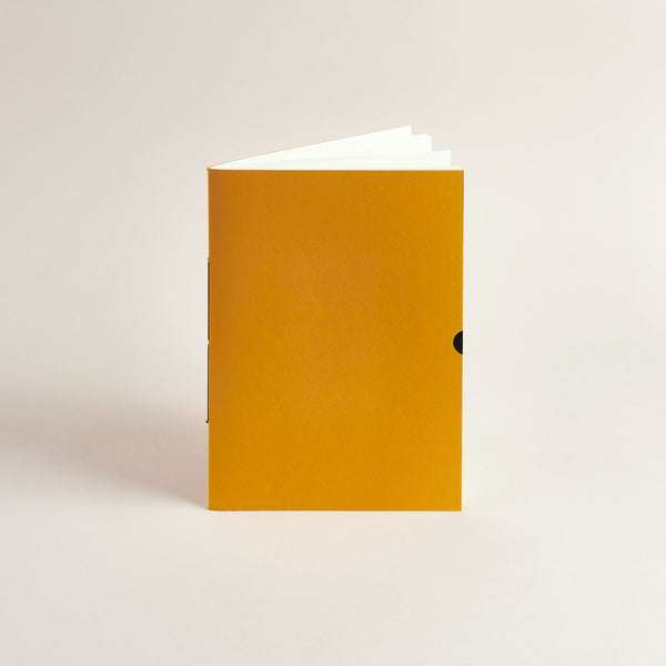 A5 Mustard Exercise Book notebook on a light beige background