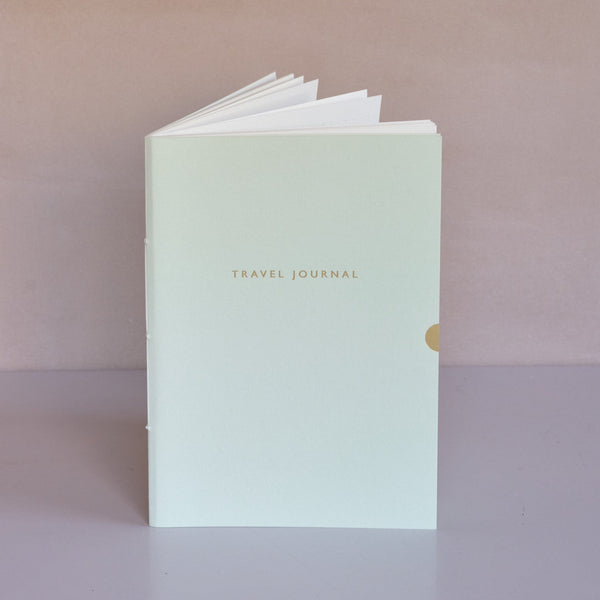 Light green travel journal with 'Travel Journal' text on a gradient background