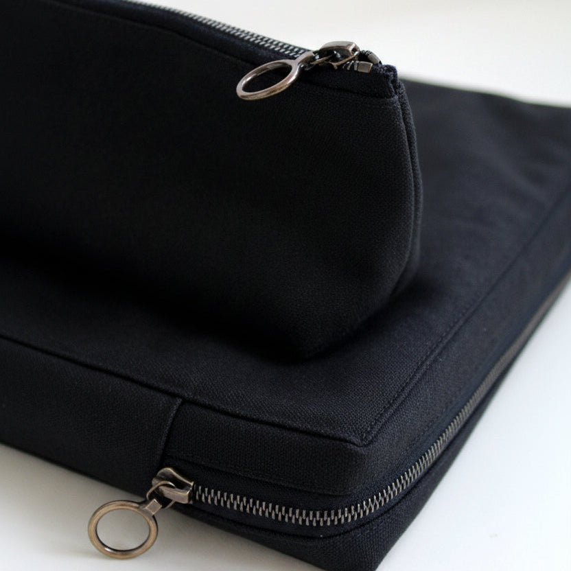 Black canvas pouch with zipper on a white background