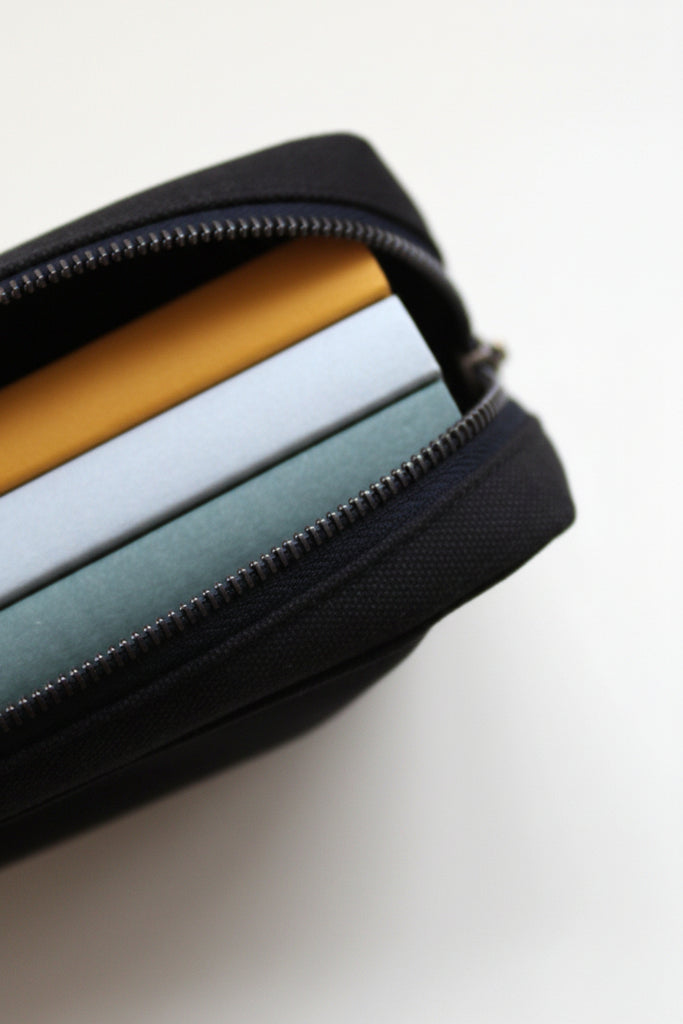 Black pouch with zipper containing colorful items on a white background