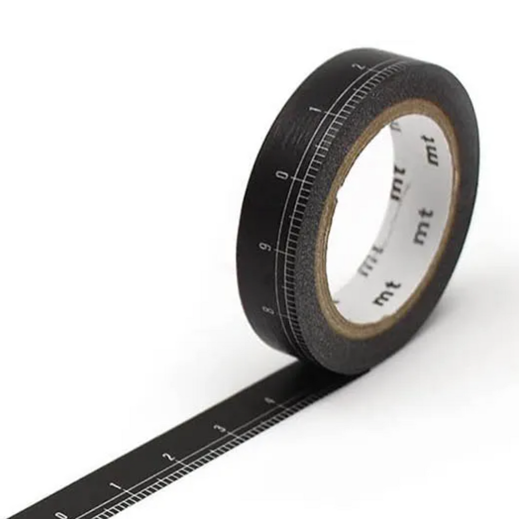 A roll of black washi tape printed with a ruler scale, shown on a clean white background with a strip of the tape unrolled diagonally.