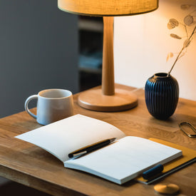 Minimal desk scene, featuring solid oak desk, Mark+Fold diary planner, Y studio solid brass paperweight and Lamy 2000 fountain pen